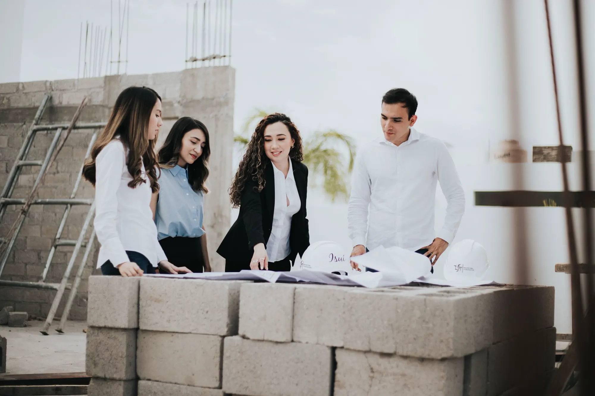 Construction professionals coordinating around project plans on site